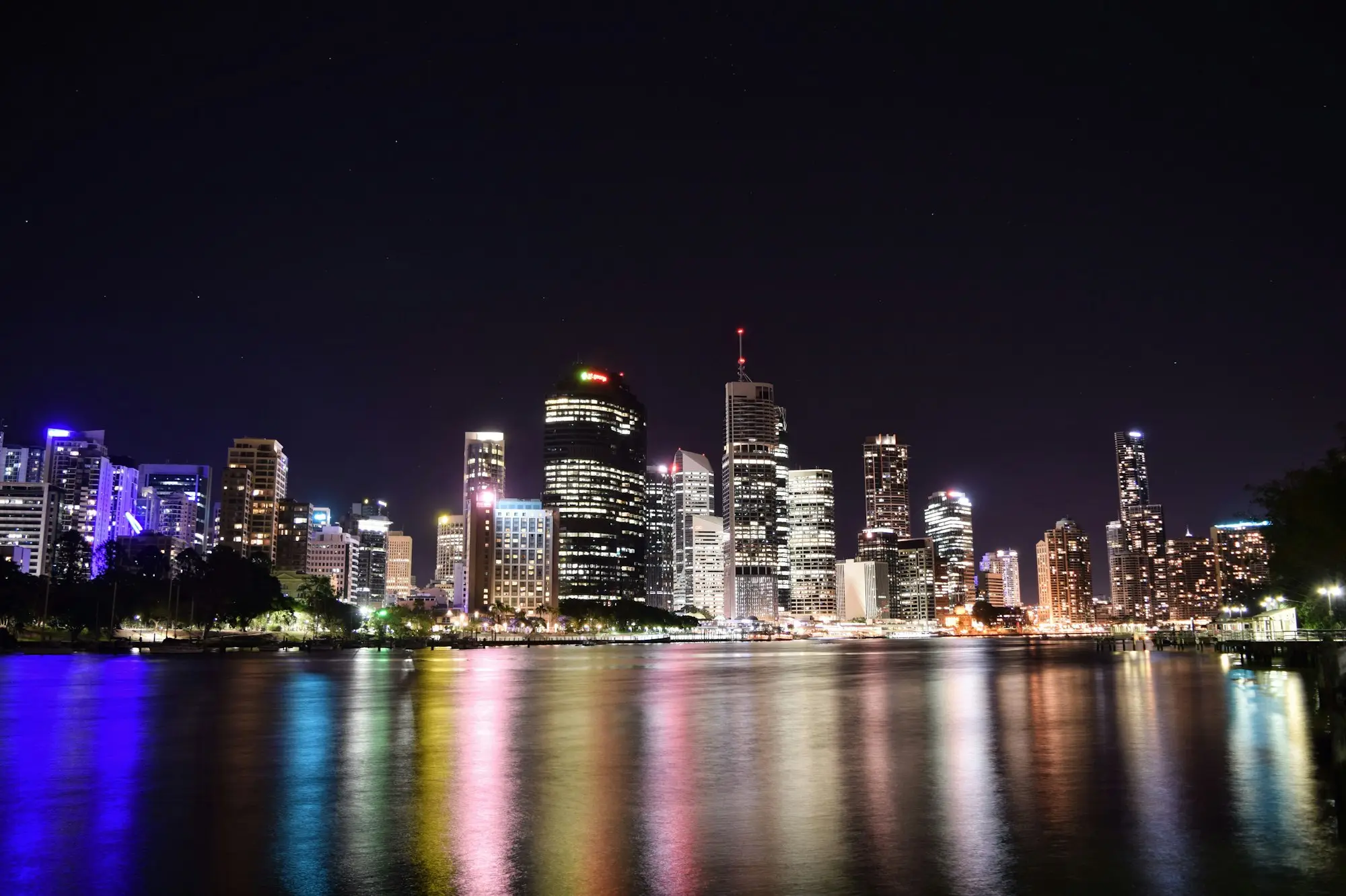 Brisbane CBD office towers lit up at night and reflected in the Brisbane River