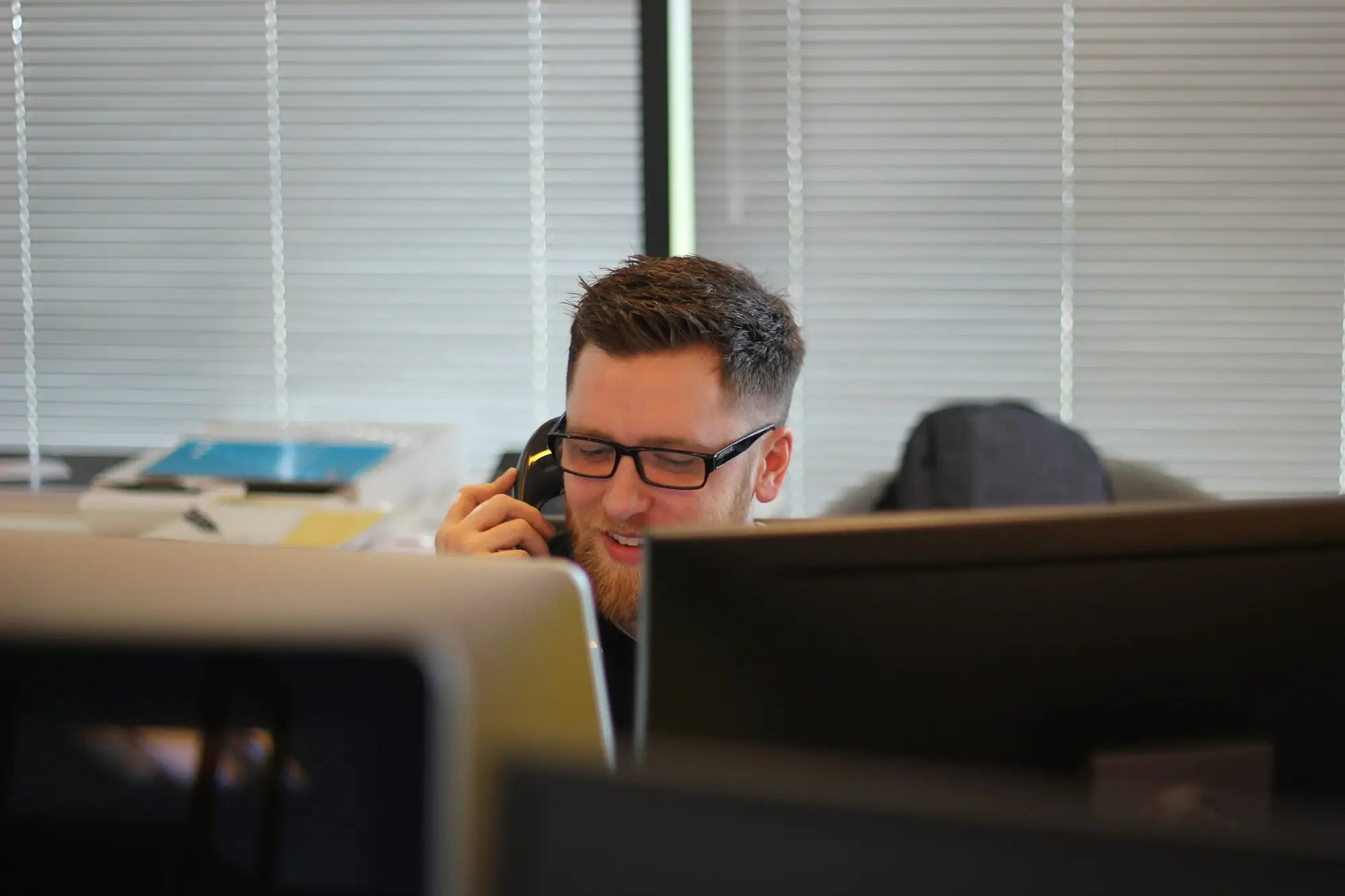 Business owner on the phone at his desk sorting out a payment
