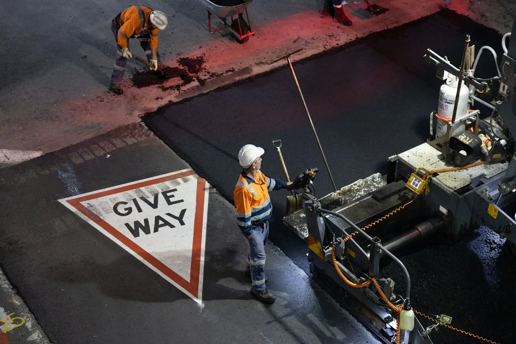 Road crew in hi-vis working beside a give way sign on an Australian worksite