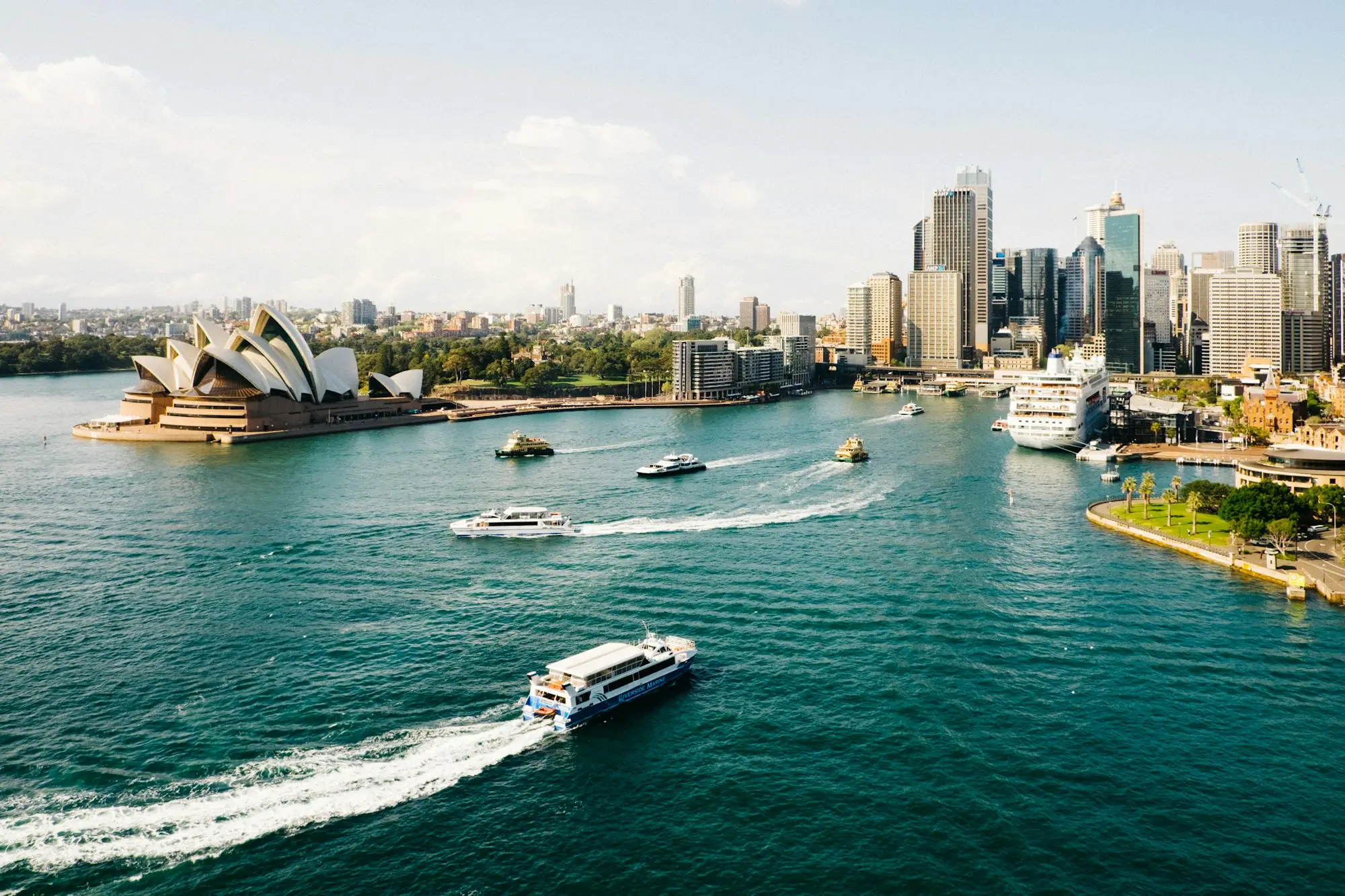 Ferries crossing Sydney Harbour in front of the Opera House and CBD towers